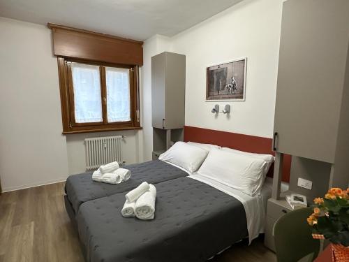 a bedroom with a bed with two towels on it at B&B Piano B in Riva del Garda