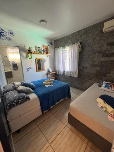 a bedroom with two beds and a mirror at Suite Lilo e Stitch - Pousada Castelo do Luar in Penha