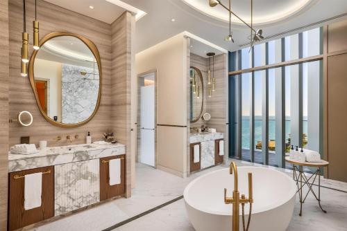 a bathroom with two sinks and a tub and a large window at Waldorf Astoria Doha Lusail in Doha
