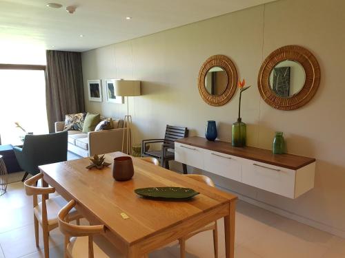 a living room with a table and a dining room at Zimbali Suites 110 in Ballito
