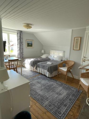 a bedroom with a bed and a table and chairs at Brunnsta Gård in Bålsta