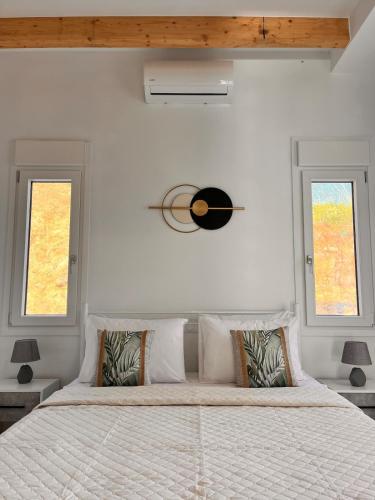 a bedroom with a large bed with two windows at Klima Breeze in Klíma