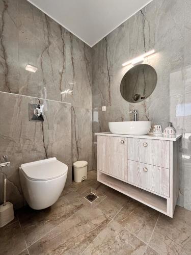a bathroom with a sink and a toilet and a mirror at Klima Breeze in Klíma