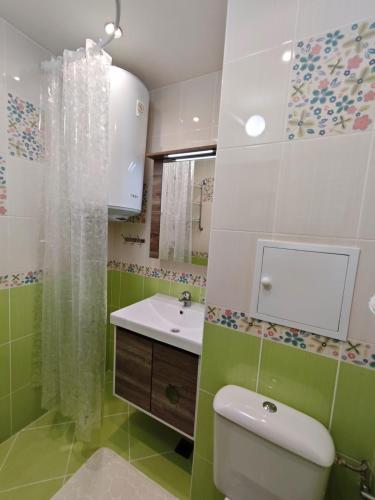 a bathroom with a white toilet and a sink at One-Bedroom flat Meden Rudnik zone B in Burgas