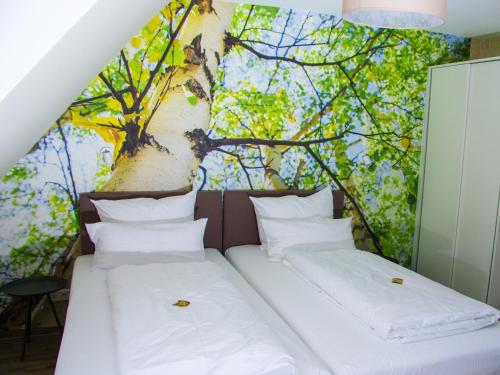 two beds in a room with a tree mural at Hotel Restaurant Anders in Schwarzenbruck
