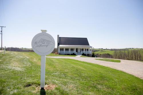 a sign in the grass in front of a building at The Gathering Premier stay for Large Groups in Millersburg