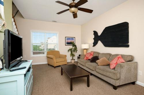 a living room with a couch and a flat screen tv at This Is It by Oak Island Accommodations in Oak Island