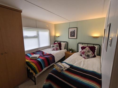 a small room with two beds and a window at Nyth y Dryw in Machynlleth