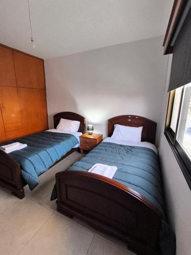 a bedroom with two beds and a window at Eva Luxury Apartment in Paphos