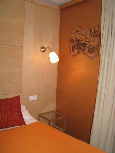 a bedroom with a bed and a lamp on a wall at Barri Antic Hostel & Pub in Andorra la Vella