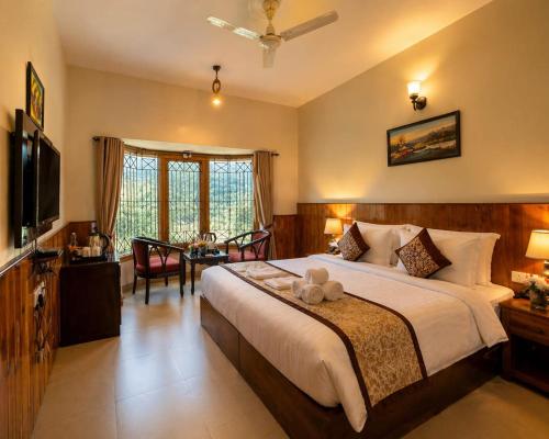 a bedroom with a large bed and a dining room at The Regal IVY Hotel in Nainital