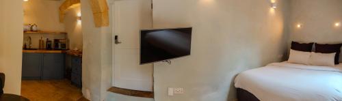 a bedroom with a bed and a flat screen tv on the wall at Talbot House by Talbot & Bons in Luqa