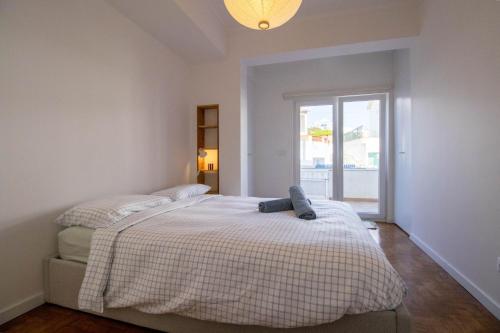 a bedroom with two beds and a window at Casa do Largo Ericeira in Ericeira