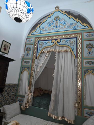 a bed with a canopy in a room at Dar lel khedija in Mahdia