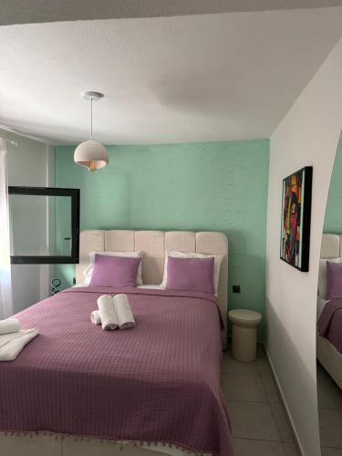 a bedroom with a purple bed with two pillows at Irida House in Skala Kallirachis
