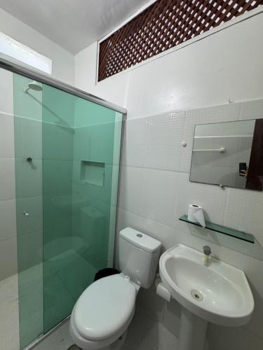 a bathroom with a toilet and a sink and a shower at Pousada Vilasboas in Parintins