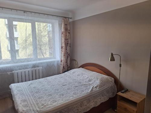 a small bedroom with a bed and a window at Тоmiк Liepaja in Liepāja