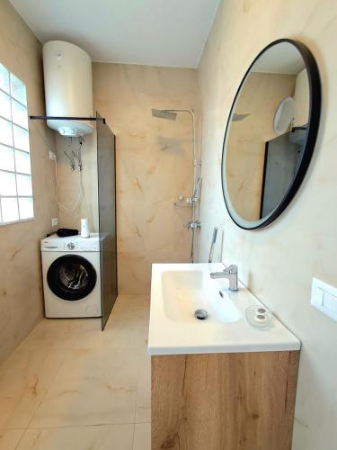 un bagno con lavandino e lavatrice di Harmony BnB a Tirana