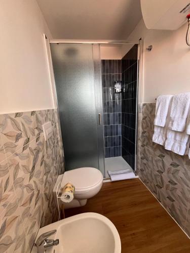 a bathroom with a shower and a toilet and a sink at Ondablurooms1 in Pizzo