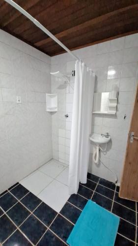 a bathroom with a white shower and a sink at Chalet da Bela Vista in Itamaracá