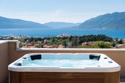a hot tub on a balcony with a view of the water at Adriatic Nest Residence in Tivat
