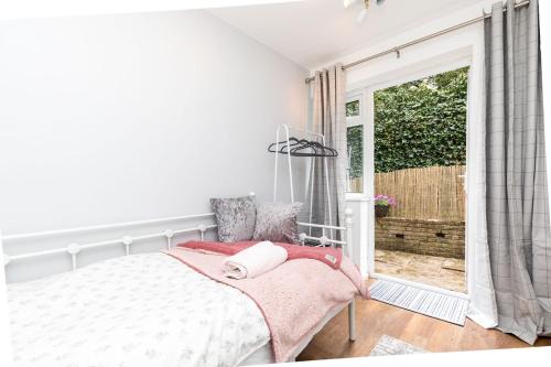 a bedroom with a bed and a large window at Rivermead - Gorgeous 3 Bed Maisonette with Patio in Horsham