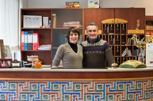 a man and woman standing at a counter in a store at Hotel Astoria in Ravenna