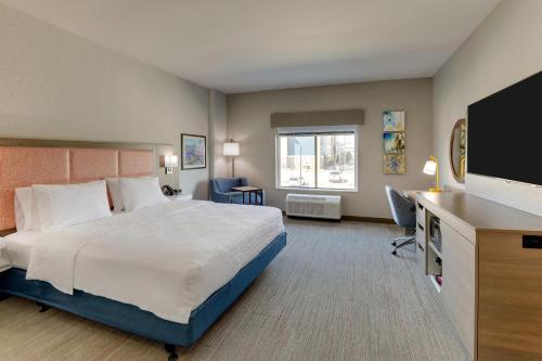 a hotel room with a bed and a flat screen tv at Hampton Inn & Suites Weatherford, Tx in Weatherford