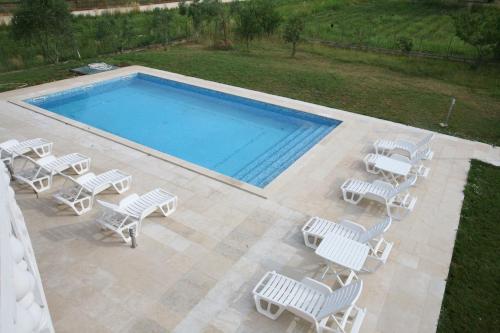 an overhead view of a swimming pool with white chairs and a group at Apartments Šeherzada in Pula
