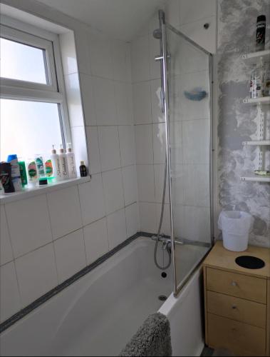 a bathroom with a shower and a bath tub at Kettering 4 night min stay with Shared Bathroom, lounge TV & kitchen free WIFI Genius on longer regular stays Professional workers Rooms in Kettering