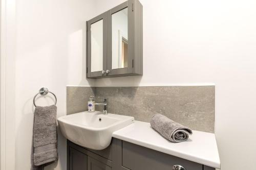 a bathroom with a sink and a mirror at Sussex House 20 - Artistic Luxe 1 Bed Apartment in Horsham