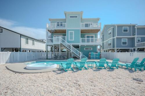 a group of chairs and a pool in front of a building at Wait N Sea by Oak Island Accommodations in Oak Island