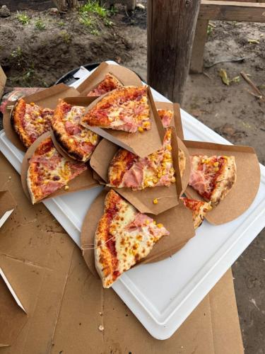 a pile of pizza on a white plate on a table at Horse Garden in Valea Groşilor