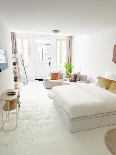 a white living room with a white bed and a couch at Atelier Marguerite, plain-pied au cœur de Tonnerre in Tonnerre