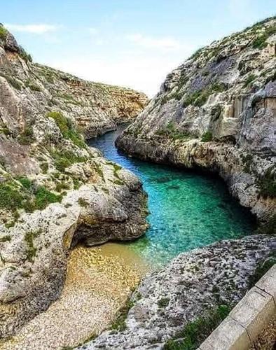 a river between two rocky mountains with blue water at Dotties Retreat Qala in Qala