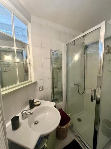 a white bathroom with a sink and a shower at Good Vibes in Grenoble