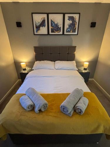 a bedroom with a large bed with towels on it at 2 Bedroom Apartment in Exhall