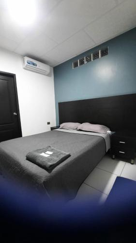 a bedroom with a bed with a blanket on it at Hotel confort in Guayaquil