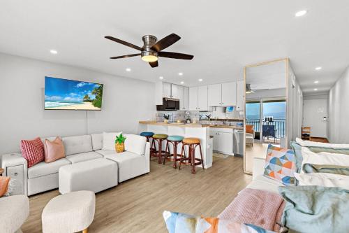 a living room with a white couch and a ceiling fan at Lahaina Roads 302 in Lahaina