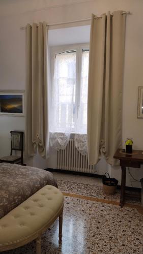 a bedroom with a bed and a window with curtains at Contessa Alba in Savona