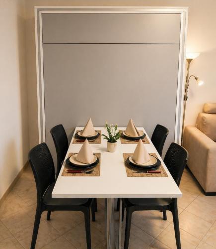 a dining room table with hats on top of it at Oxygen Riva del Garda Monolocale con Balcone e Bike Room in Riva del Garda