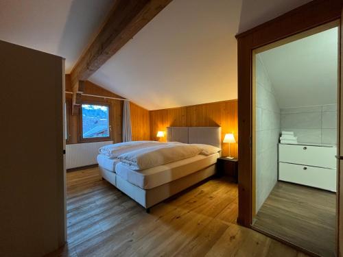 a bedroom with a large bed and a large mirror at Ferienlenk Mountain Village in Lenk