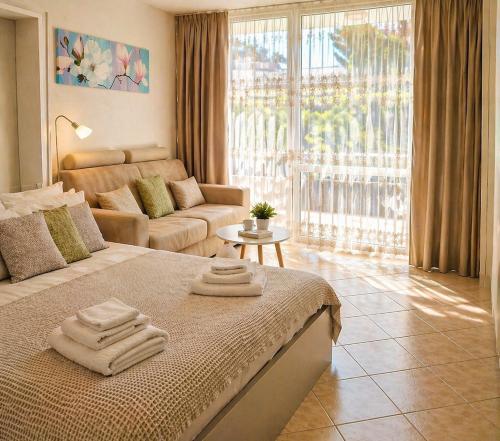 a bedroom with a bed and a living room with a couch at Oxygen Riva del Garda Monolocale con Balcone e Bike Room in Riva del Garda