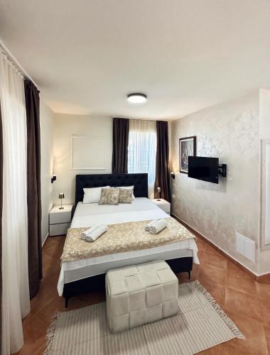 a bedroom with a large bed and a television at Stone Garden Residence in Budva