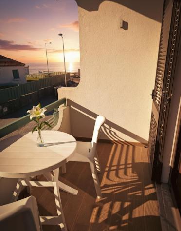 a balcony with a table and a vase of flowers at Hotel Areias Claras in Viana do Castelo