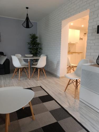 a living room with a table and white chairs at MoRze MielNo in Mielno