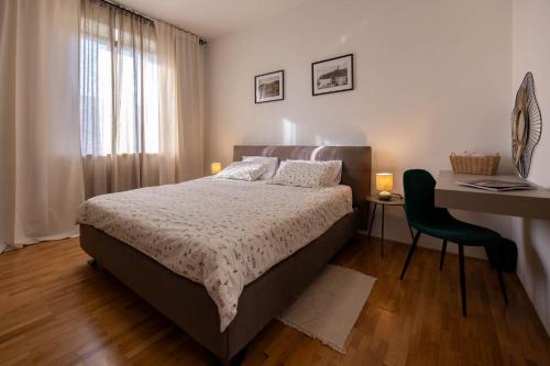 a bedroom with a bed and a desk and a chair at Lume Capi in Labin