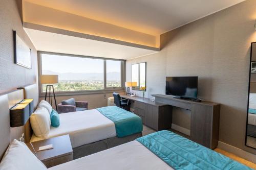 a hotel room with two beds and a television at Hotel Terrado Rancagua in Rancagua