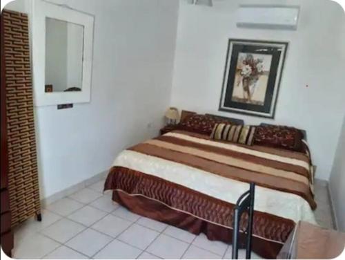a bedroom with a large bed in a white room at Chez Lilly in Oranjestad