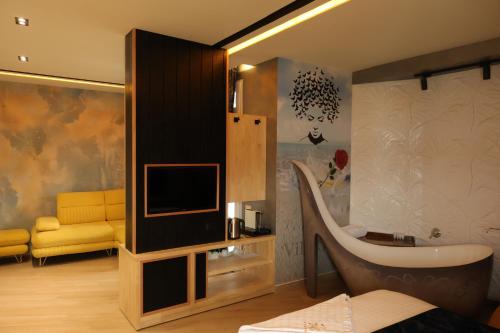 a bathroom with a tub and a tv in a room at Vila One Beach Hotel in Durrës